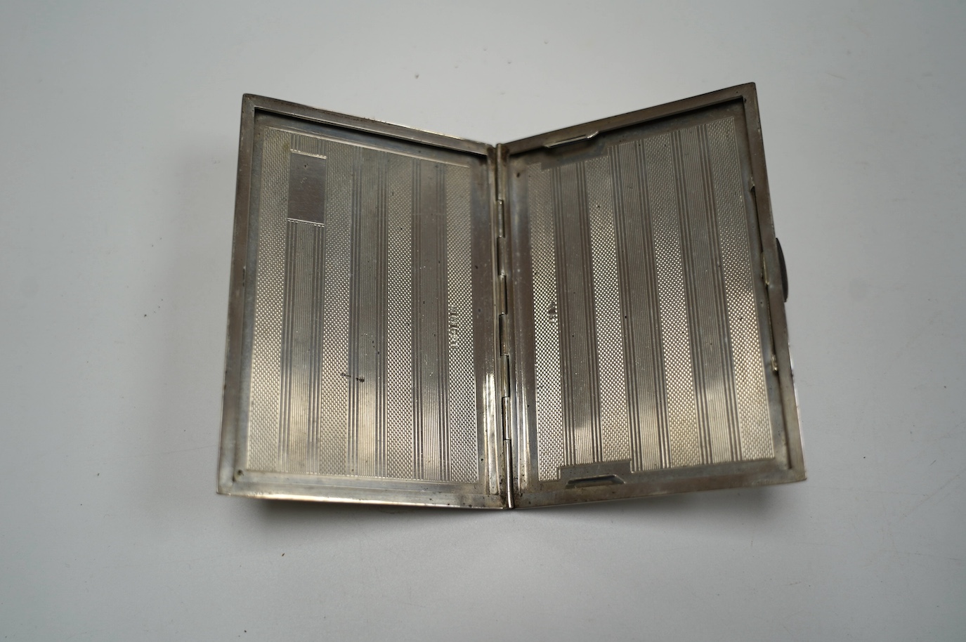 A George V engine turned silver cigarette case, Birmingham, 1945, 12.4cm, 6.5oz. Condition - fair